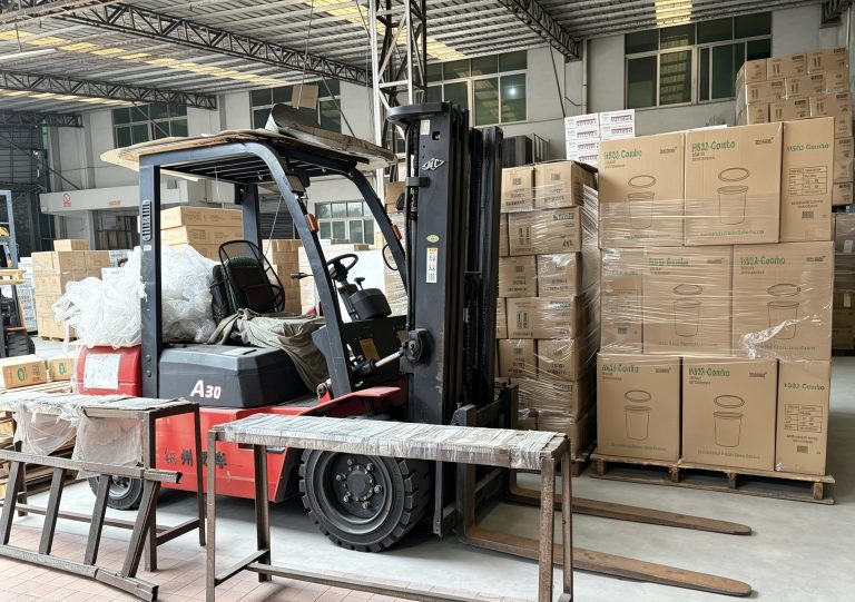 Warehouse forklift handling export cartons before loading